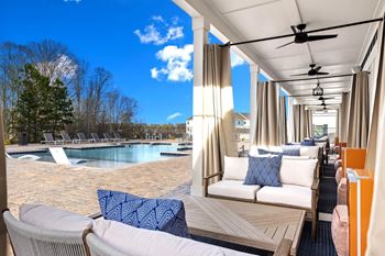 a patio with couches and chairs and a swimming pool